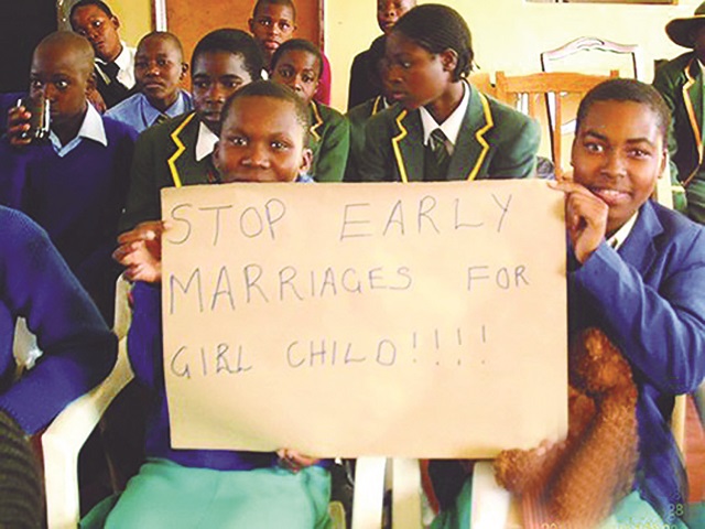 School children lift a placard denouncing child mariages