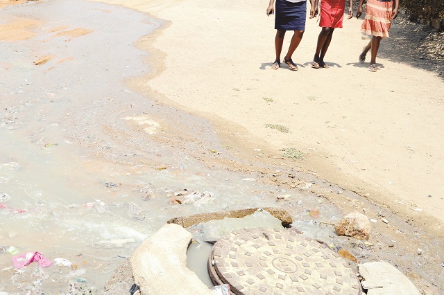 Bulawayo residents negotiate their way past a burst manhole with spilling sewage that has blocked a road in Mpopoma suburb in this file photo. Sewer pipe bursts are now common in major cities and towns as councils fail to contain the problem