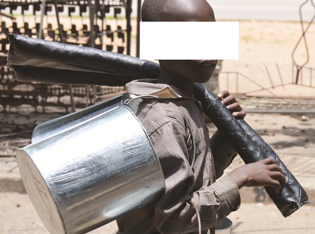 A child sells metal buckets and door stoppers at Mpopoma shopping centre, Bulawayo, in this file photo